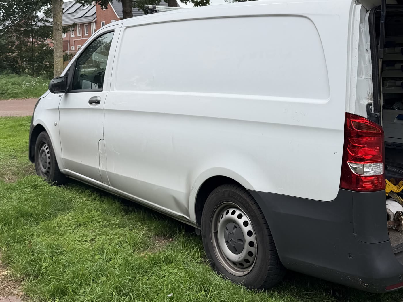 Witte werkbus van RolluikBroers, van opzij gezien